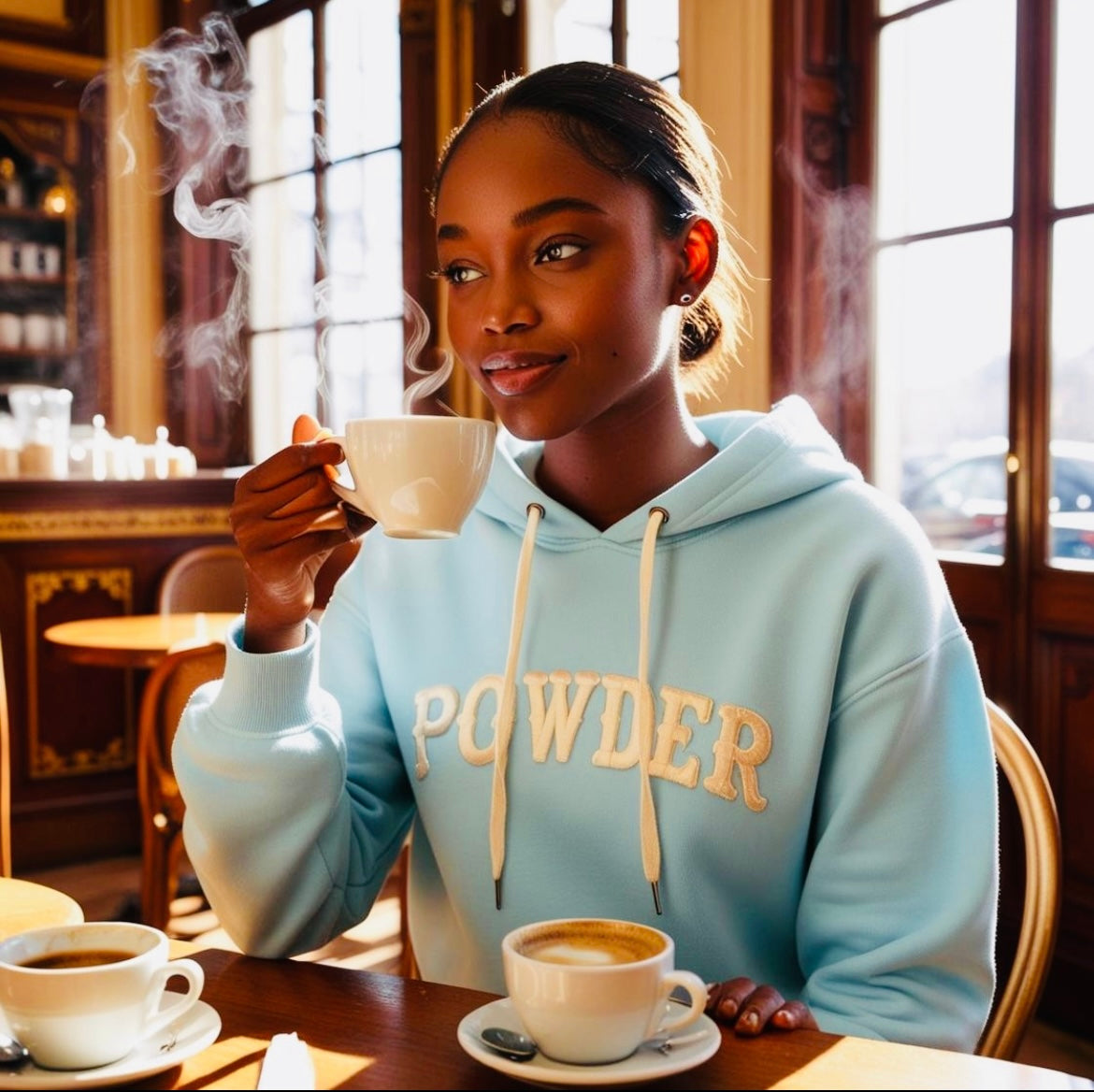 Woman in Alaskan Blue Hoodie having coffee - PowderLA luxury streetwear
