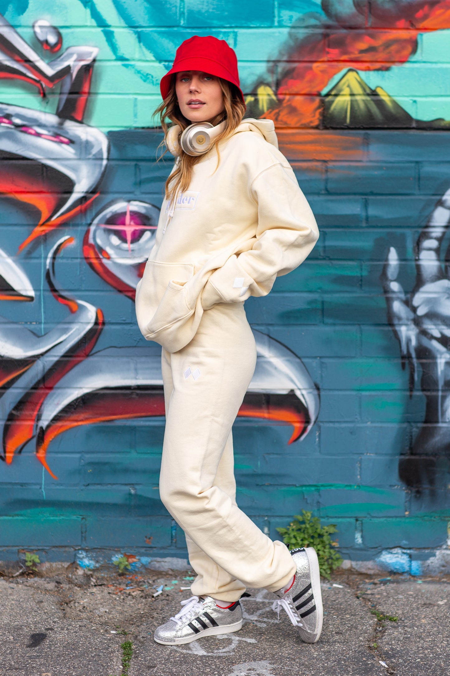 Full outfit shot of cream hoodie and sweats - artistic city background