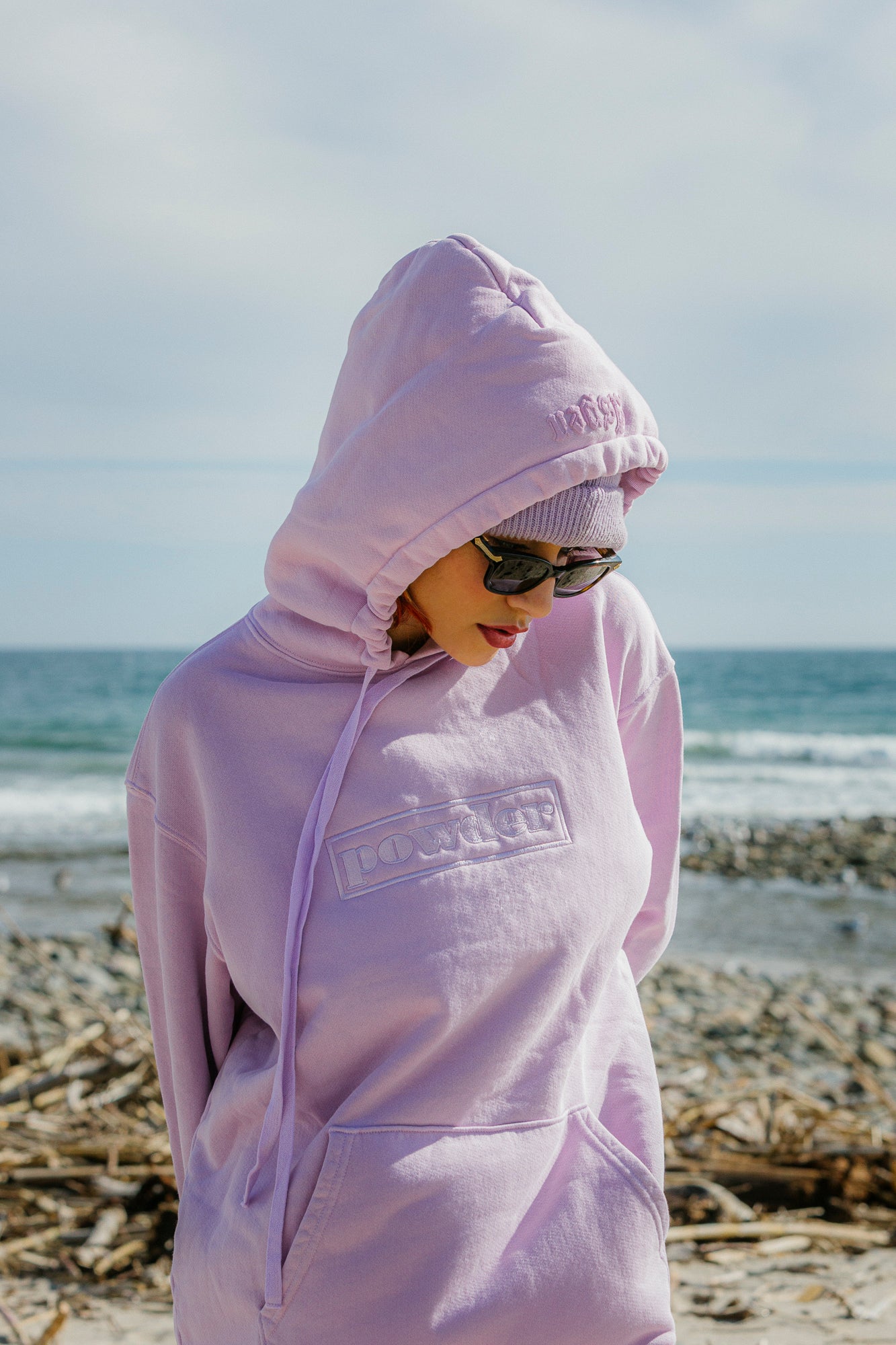 Model in lavender pink hoodie walking along shoreline - PowderLA